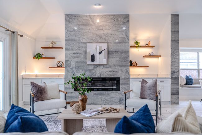 Living room with a high end fireplace, light tile patterned flooring, and lofted ceiling | Image 21