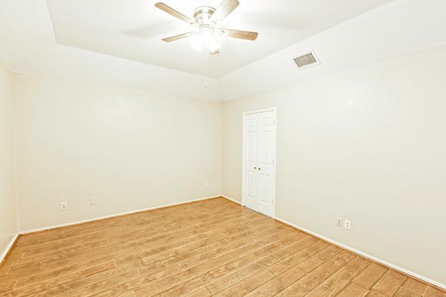 Empty room featuring light wood finished floors and a ceiling fan | Image 19
