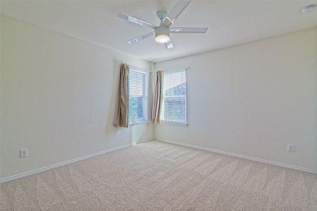 Carpeted spare room featuring ceiling fan and a smoke detector | Image 26