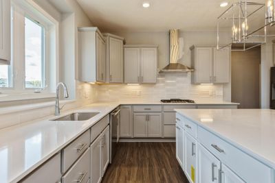 (Photo of a decorated model, actual homes finishes will vary) Welcome to the Snelling! This spacious gourmet kitchen features a large center island, quartz countertops, LVP floors, stainless appliances and more. | Image 2