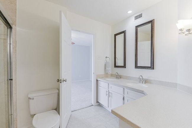 Bathroom featuring tile patterned flooring, visible vents, a sink, and toilet | Image 15