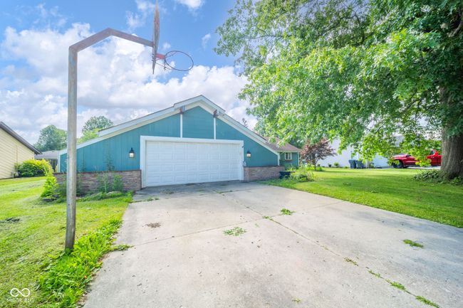 view of front of home with a front yard, an attached garage, and driveway | Image 4