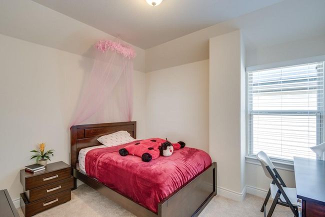 Bedroom with light colored carpet, baseboards, and multiple windows | Image 22