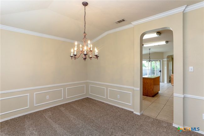 Formal Dining room looking into the kitchen, featuring a chandelier. | Image 6