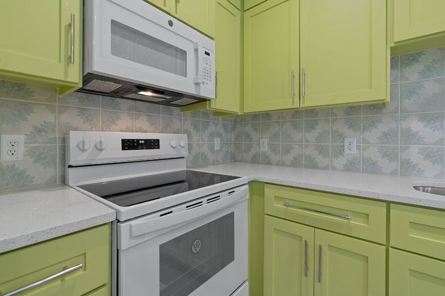 Kitchen featuring decorative backsplash, green cabinets, and white appliances | Image 29