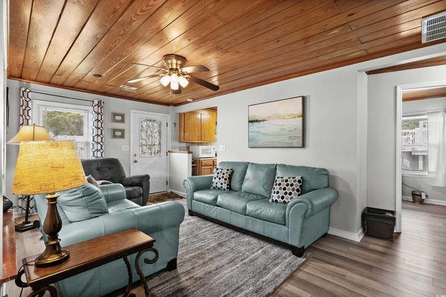 Living room with wood ceiling, baseboards, healthy amount of natural light, ceiling fan, and crown molding | Image 30