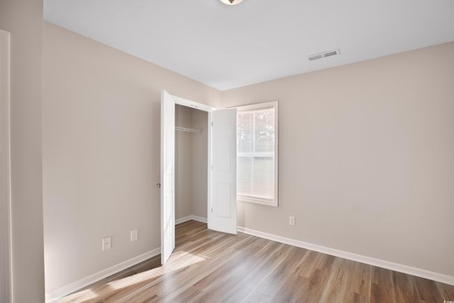 Unfurnished bedroom with wood finished floors and a closet | Image 7