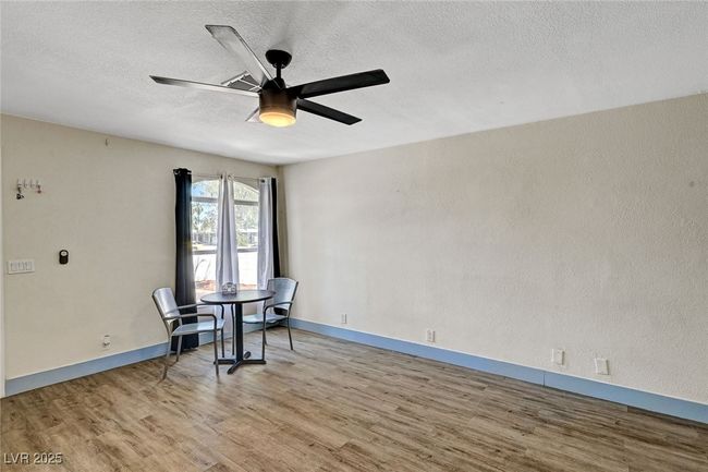 Unfurnished dining area featuring wood finished floors, ceiling fan, and a textured ceiling | Image 10