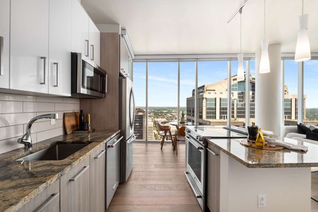 Designed to maximize flow and capitalize on views, the kitchen is anchored by the island, opening to the living area and the perfect dining space beside the windows. | Image 6