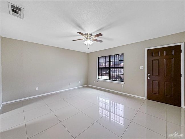 Spare room with a textured ceiling, ceiling fan, and light tile patterned floors | Image 8