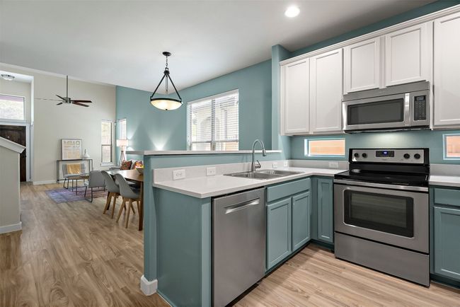Stainless steel appliances include a Bosch dishwasher, electric range and built-in microwave | Image 16