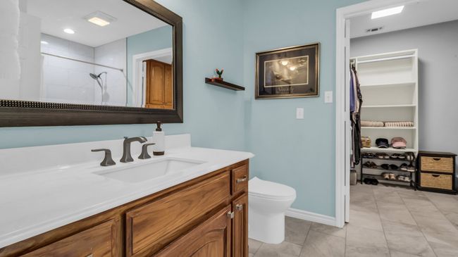 Bathroom with vanity, baseboards, toilet, visible vents, and a tile shower | Image 20