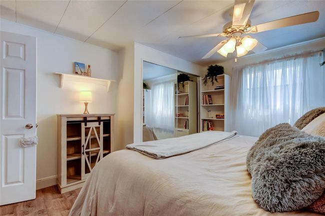 40. Bedrooom #2 (11.6' x 13.2') Offers Standard Closet w Mirrored Sliders, Ceiling Fan, & Tasteful Furnishings.. Bench, Book Shelves . | Image 39