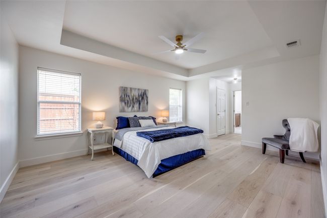 Bedroom with a raised ceiling, light wood-style flooring, a ceiling fan, and a closet | Image 16