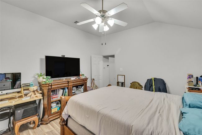 Bedroom with wood finished floors, lofted ceiling, and a ceiling fan | Image 19