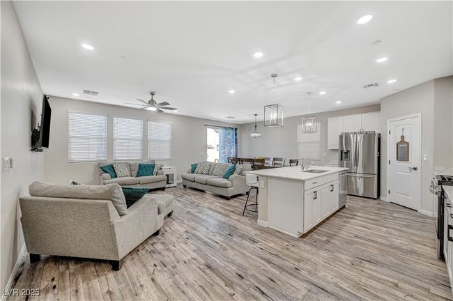 Living area with light wood-type flooring, recessed lighting, baseboards, and ceiling fan | Image 9