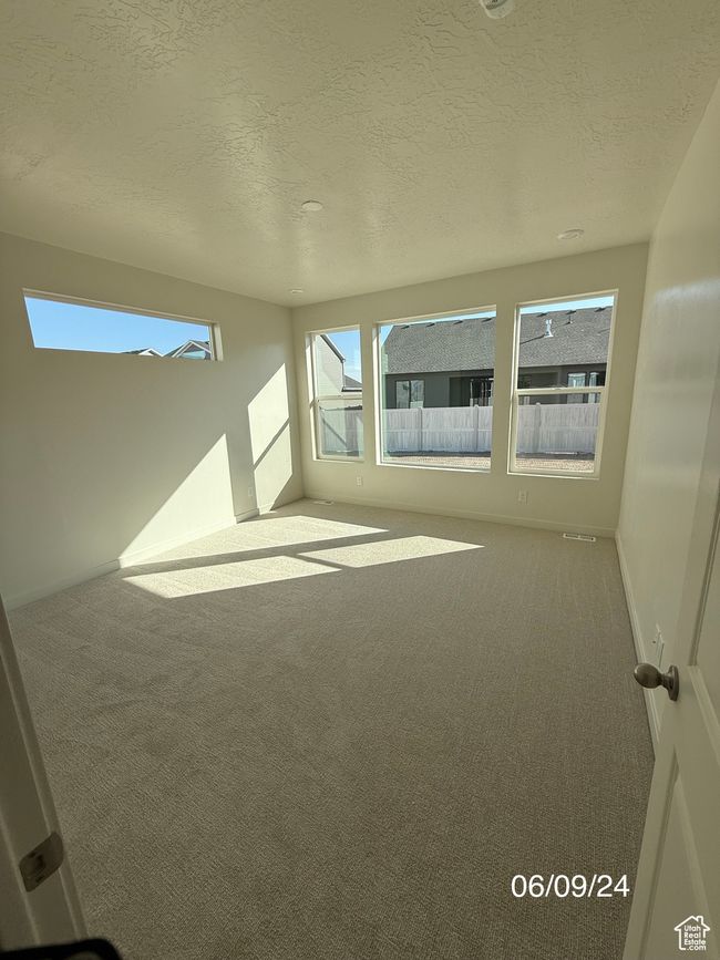 Spare room featuring carpet flooring, a textured ceiling, and baseboards | Image 5