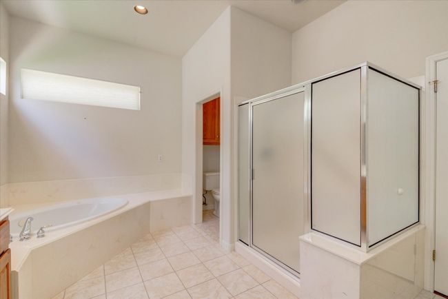 Primary Bathroom featuring a bath, a stall shower, and tile patterned floors | Image 18