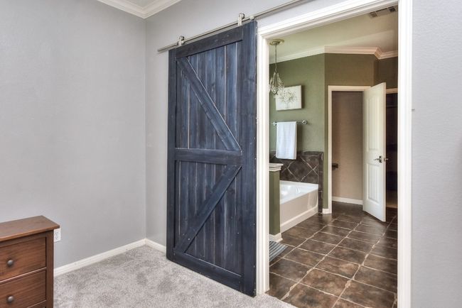 A charming rustic barn door welcomes you to the spa-like primary bathroom! | Image 21