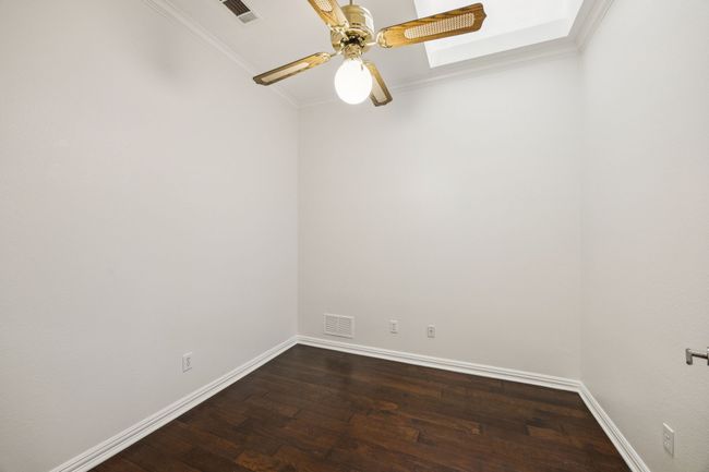 Office with wood floors, a skylight, a ceiling fan, crown molding, and baseboards | Image 14