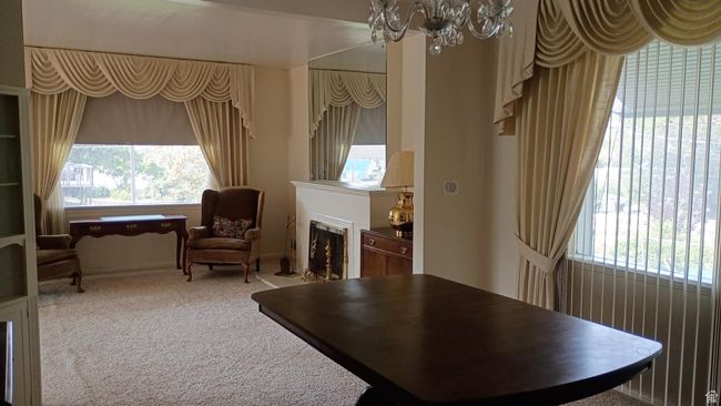 Sitting room with light carpet, a chandelier, and a fireplace | Image 15