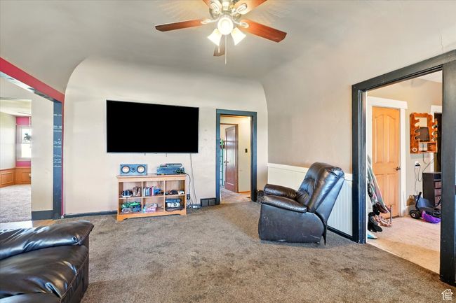Carpeted living area featuring ceiling fan and vaulted ceiling | Image 4
