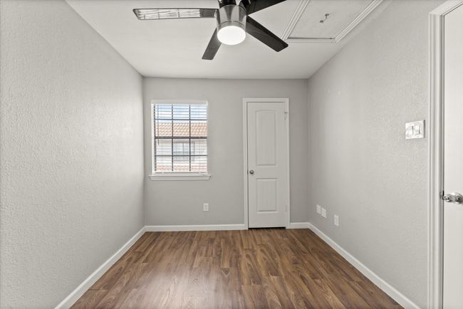 Spare room featuring a textured wall, a ceiling fan, and dark wood-style floors | Image 21