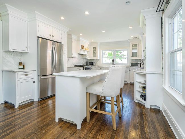 Kitchen with stainless steel appliances, white cabinetry, tasteful backsplash, dark wood-type flooring, and recessed lighting | Image 8