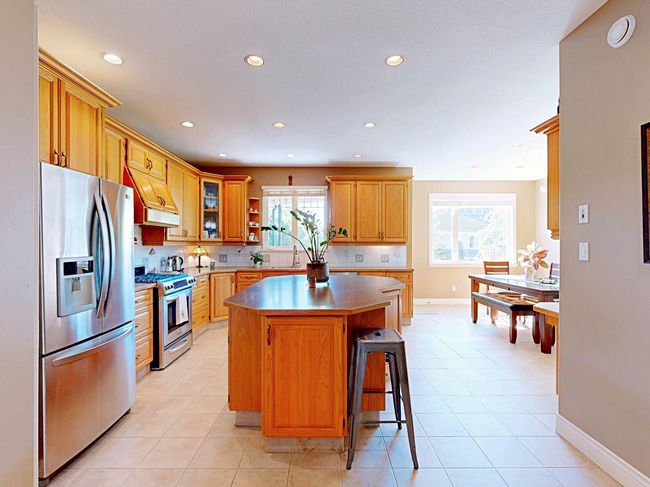 Kitchen with stainless steel appliances, premium range hood, recessed lighting, a kitchen island, and backsplash | Image 8