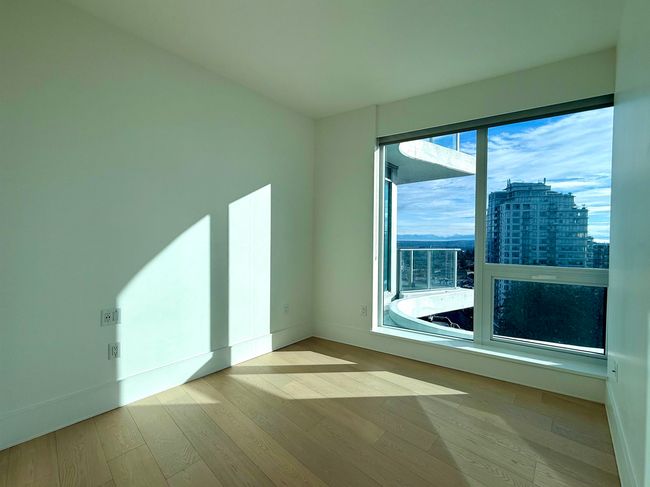 Empty room featuring a city view, baseboards, and wood finished floors | Image 10