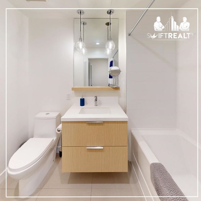 Full bath featuring shower / bathtub combination, vanity, tile patterned flooring, and toilet | Image 7