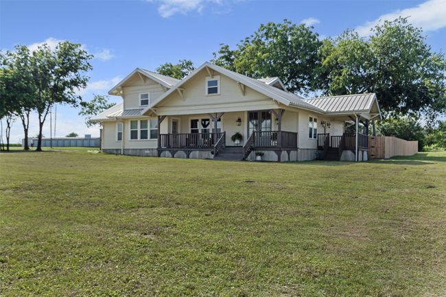 View of front of house with metal roof, covered porch, and a front lawn | Image 5