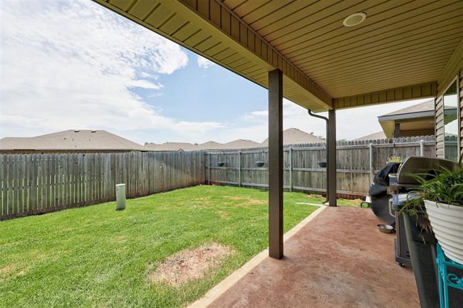 Fenced backyard with a patio | Image 38