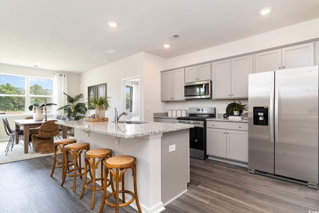 Kitchen with dark wood-style floors, visible vents, a sink, gray cabinetry, and appliances with stainless steel finishes | Image 7