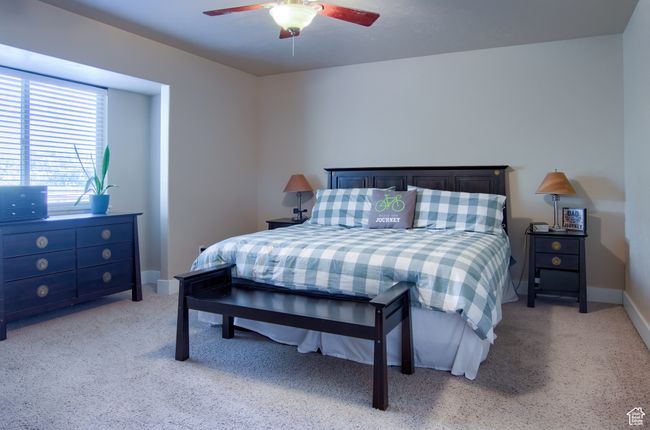 Bedroom featuring a ceiling fan, baseboards, and light carpet | Image 12
