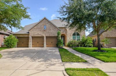 What an incredible place to call home! This sprawling, 2-story, single family brick treasure is located at 20622 Elderwood Terrace Drive, Richmond, TX, in the Long Meadow Farms master planned community. (Shown here are the triple attached garages, covered front entrance and meticulous front landscaping.) | Image 1