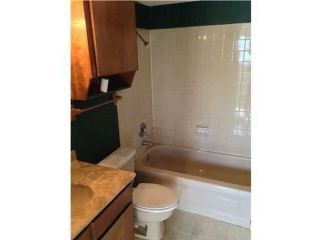 Full bathroom with vanity, tile patterned flooring, toilet, and shower / tub combination | Image 4