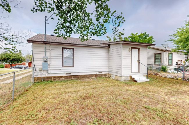 Back of house with entry steps, crawl space, a fenced backyard, and roof with shingles | Image 16