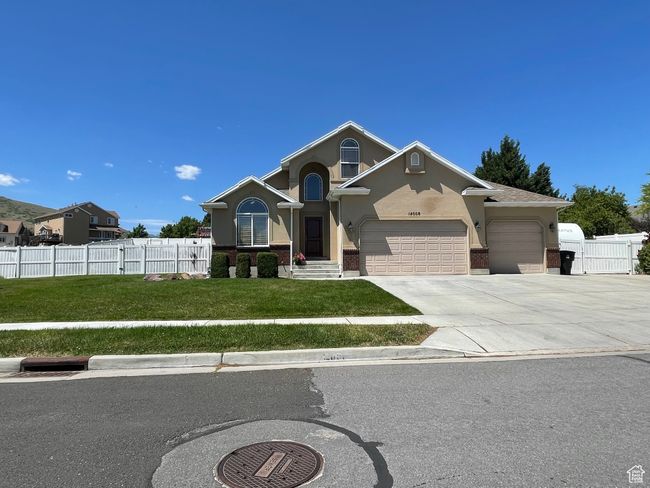 View of front facade with an attached garage, driveway, stucco siding, and brick siding | Image 5