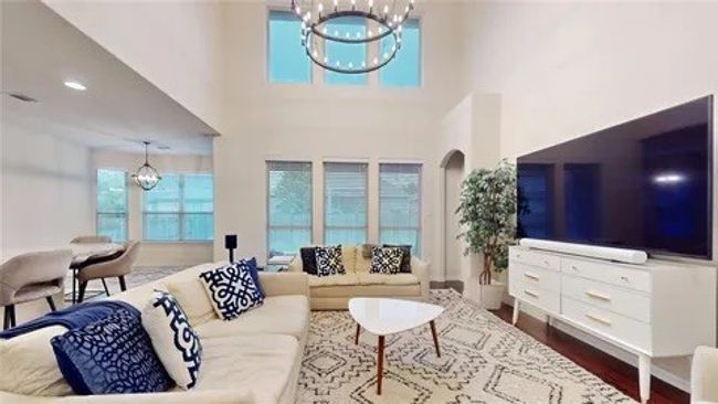 Living room with a chandelier, healthy amount of natural light, a high ceiling, and dark wood-type flooring | Image 15