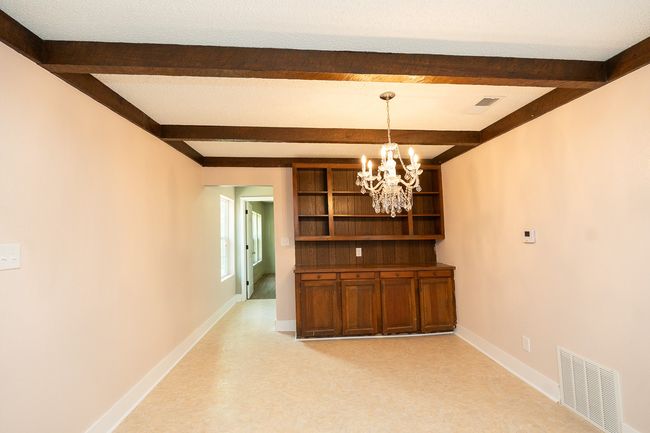 Unfurnished dining area featuring a chandelier and beam ceiling | Image 18