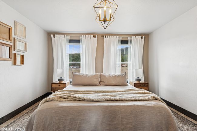 Bedroom with baseboards, an inviting chandelier, and wood finished floors | Image 29