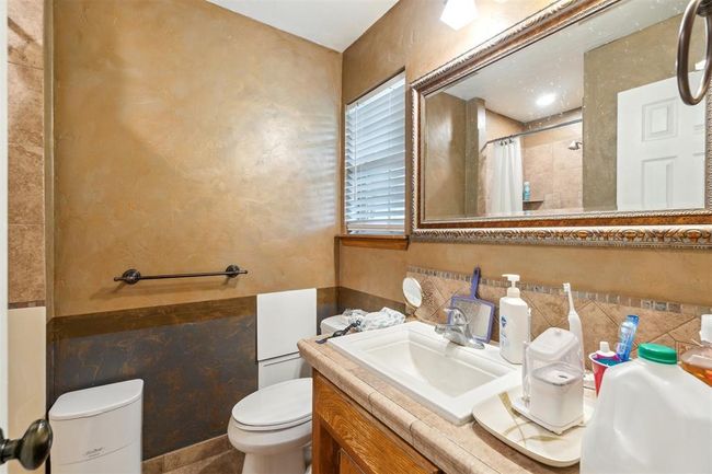 Bathroom with tile walls, vanity, tiled shower, and a wainscoted wall | Image 22