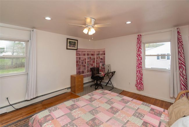 Primary bedroom with hardwood floors, celing fan and recessed lights. | Image 8