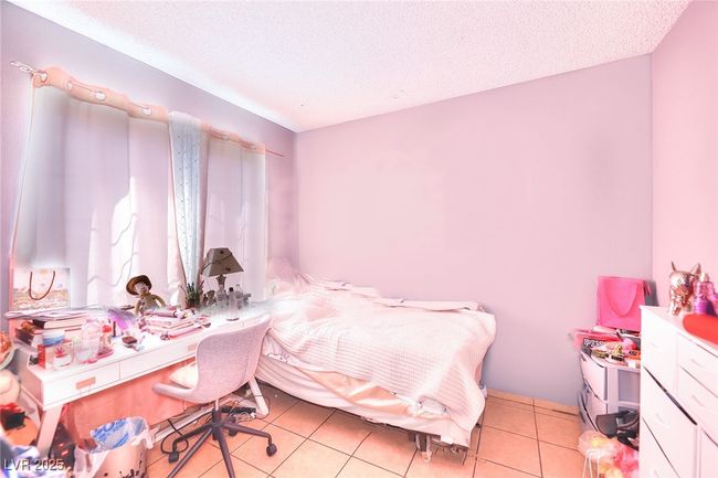 Bedroom featuring a textured ceiling and light tile patterned floors | Image 10