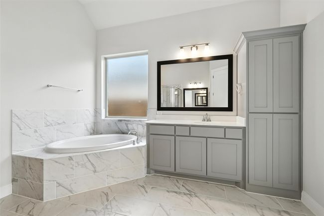 Bathroom featuring vanity, a bath, marble finish flooring, an enclosed shower, and lofted ceiling | Image 18