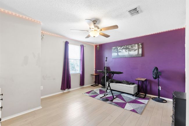 Workout area featuring a ceiling fan, a textured ceiling, and light wood-style flooring | Image 23