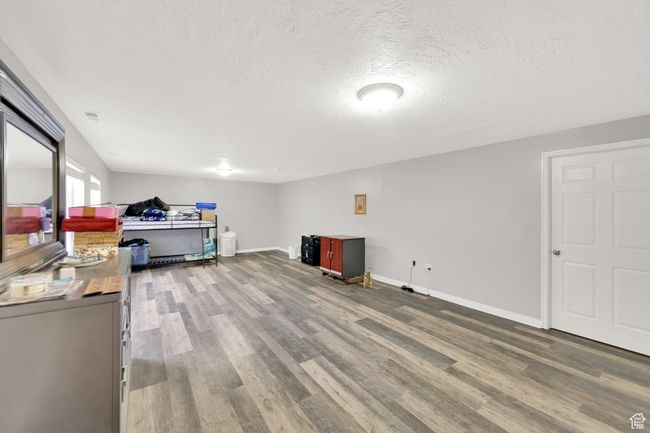 Basement featuring wood finished floors and a textured ceiling | Image 16