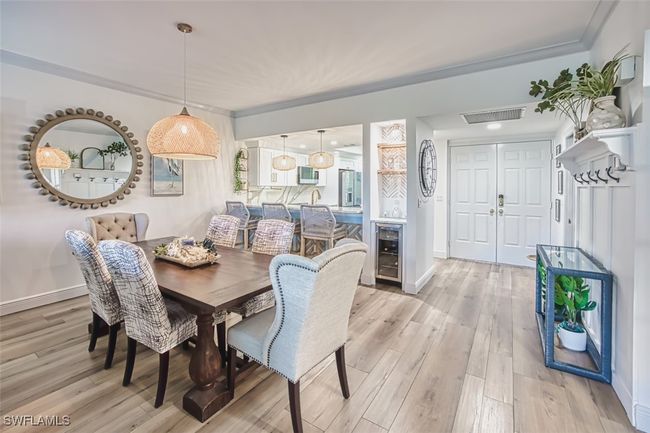 Dining area with wine cooler, light wood-style floors, and crown molding | Image 15