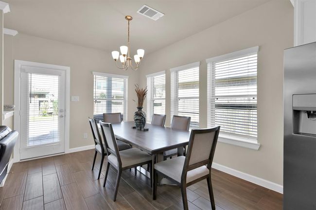 Surrounded by windows, this dining room provides the perfect setting for quick daily meals or lavish dinner party gatherings. | Image 10